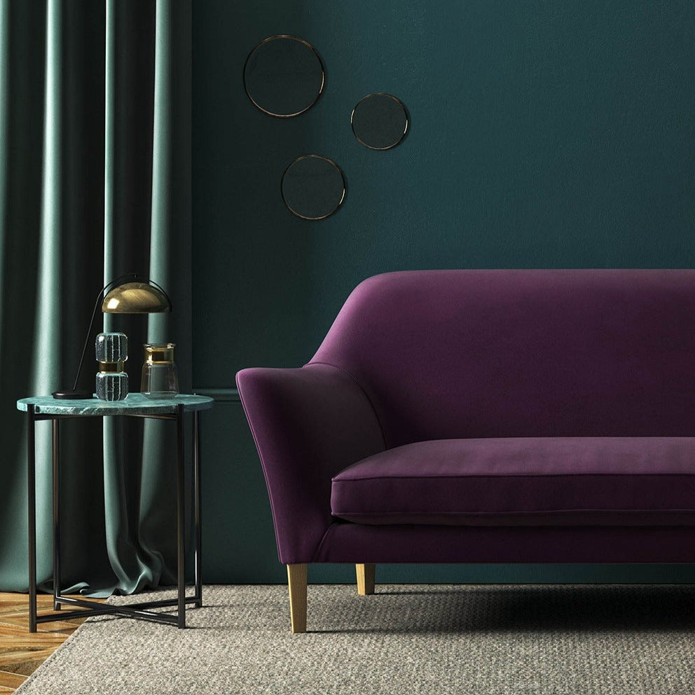 Sofa covered in a purple velvet upholstery fabric