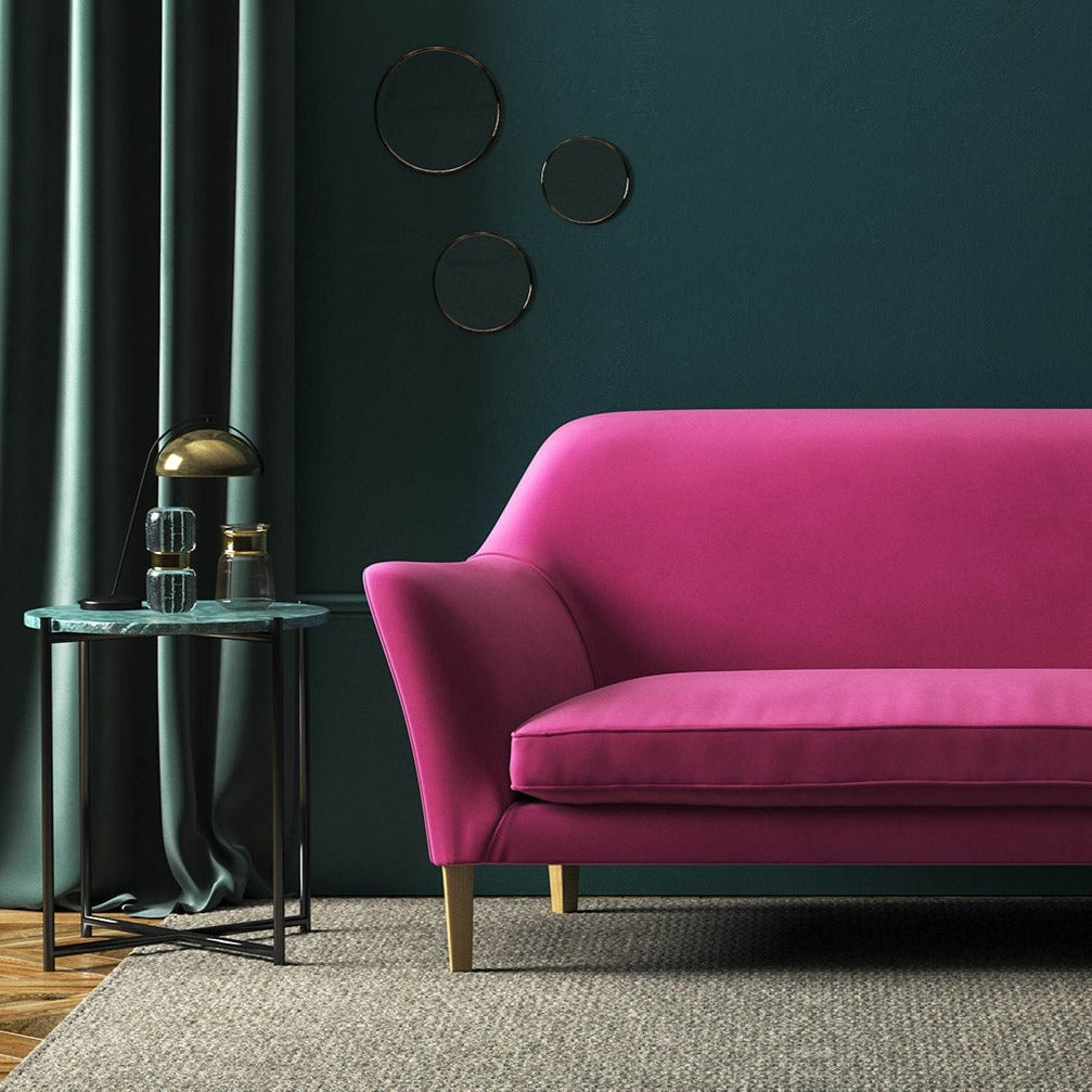 Sofa covered in a pink velvet upholstery fabric
