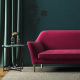 Sofa covered in a pink velvet upholstery fabric
