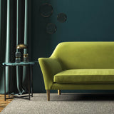 Sofa covered in a green velvet upholstery fabric