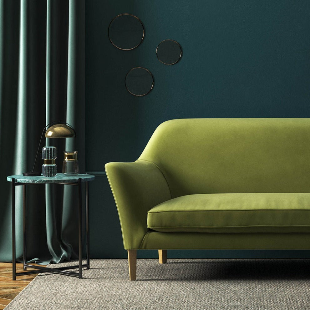 Sofa covered in a green velvet upholstery fabric