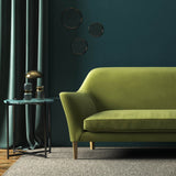Sofa covered in a green velvet upholstery fabric
