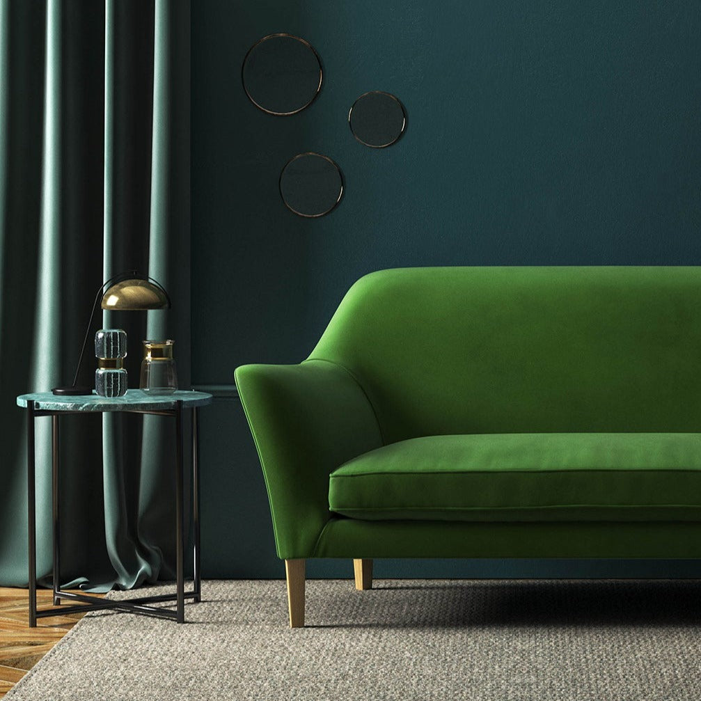 Sofa covered in a green velvet upholstery fabric
