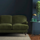 Sofa covered in a green velvet upholstery fabric
