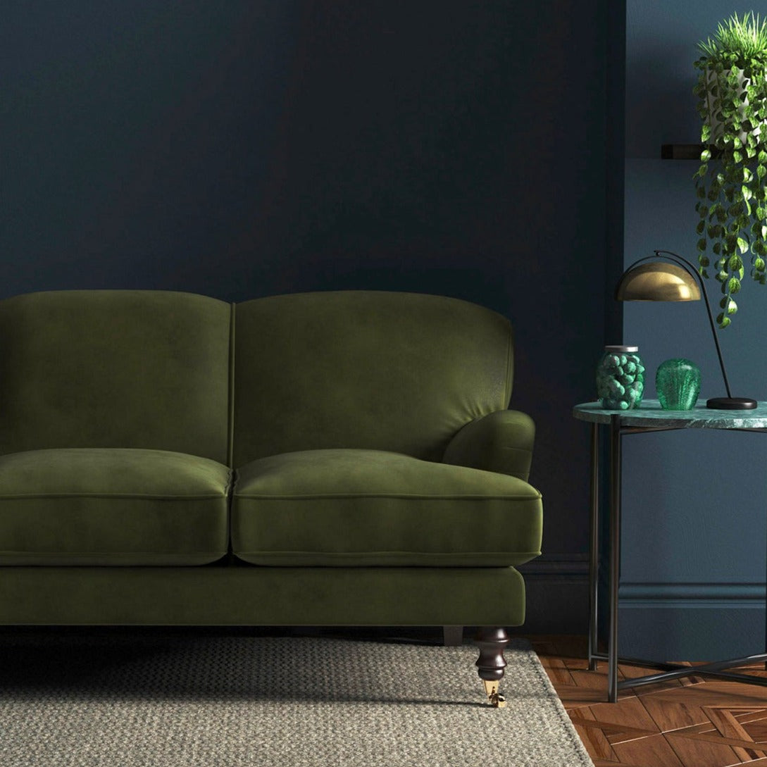 Sofa covered in a green velvet upholstery fabric