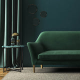 Sofa covered in a green velvet upholstery fabric