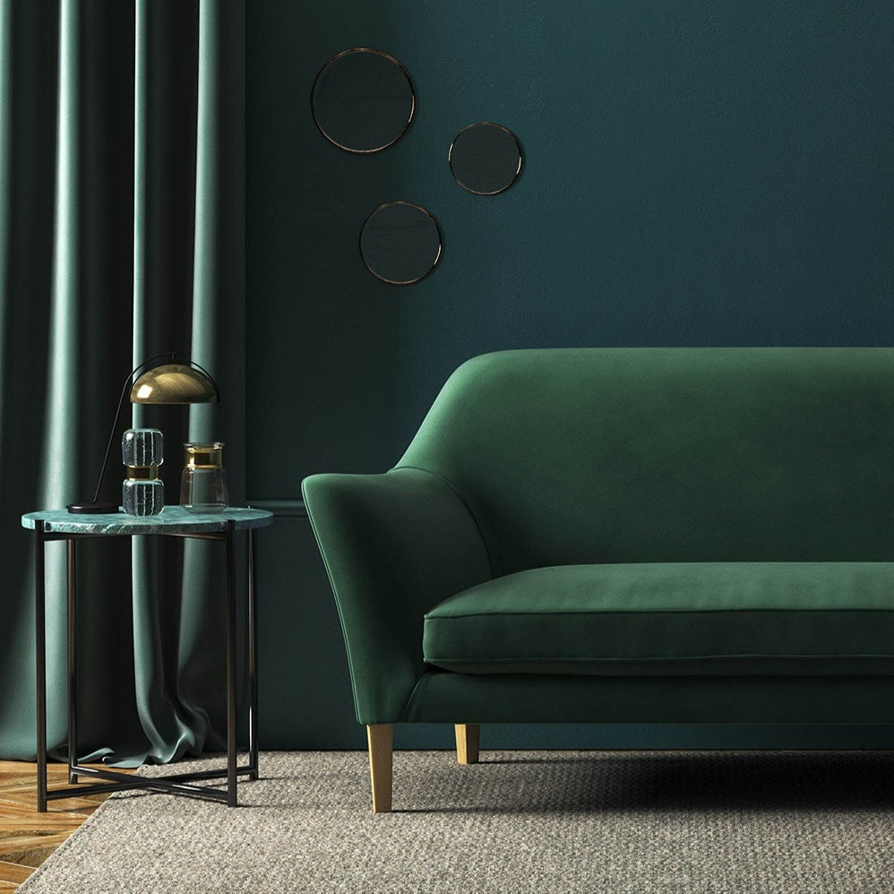 Sofa covered in a green velvet upholstery fabric