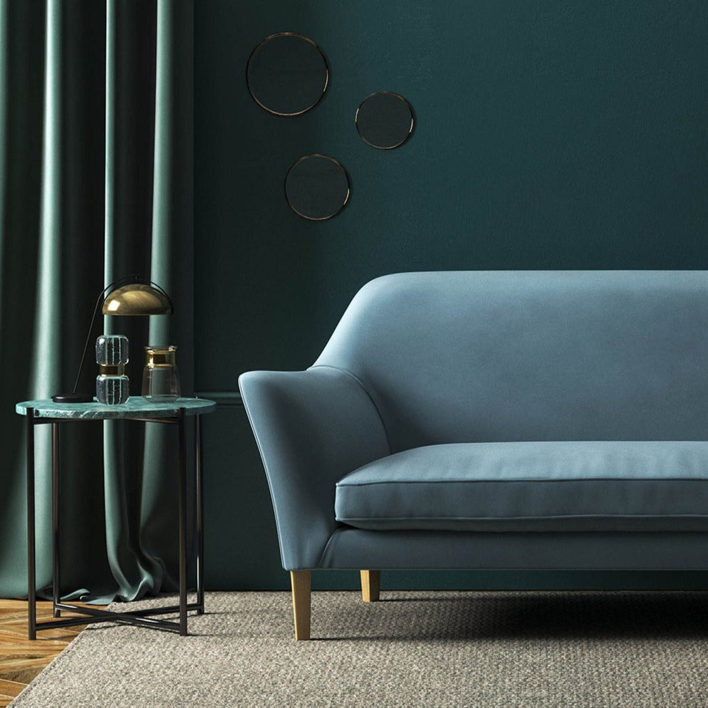 Sofa covered in a blue velvet upholstery fabric