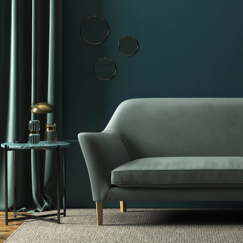 Sofa covered in a blue velvet upholstery fabric