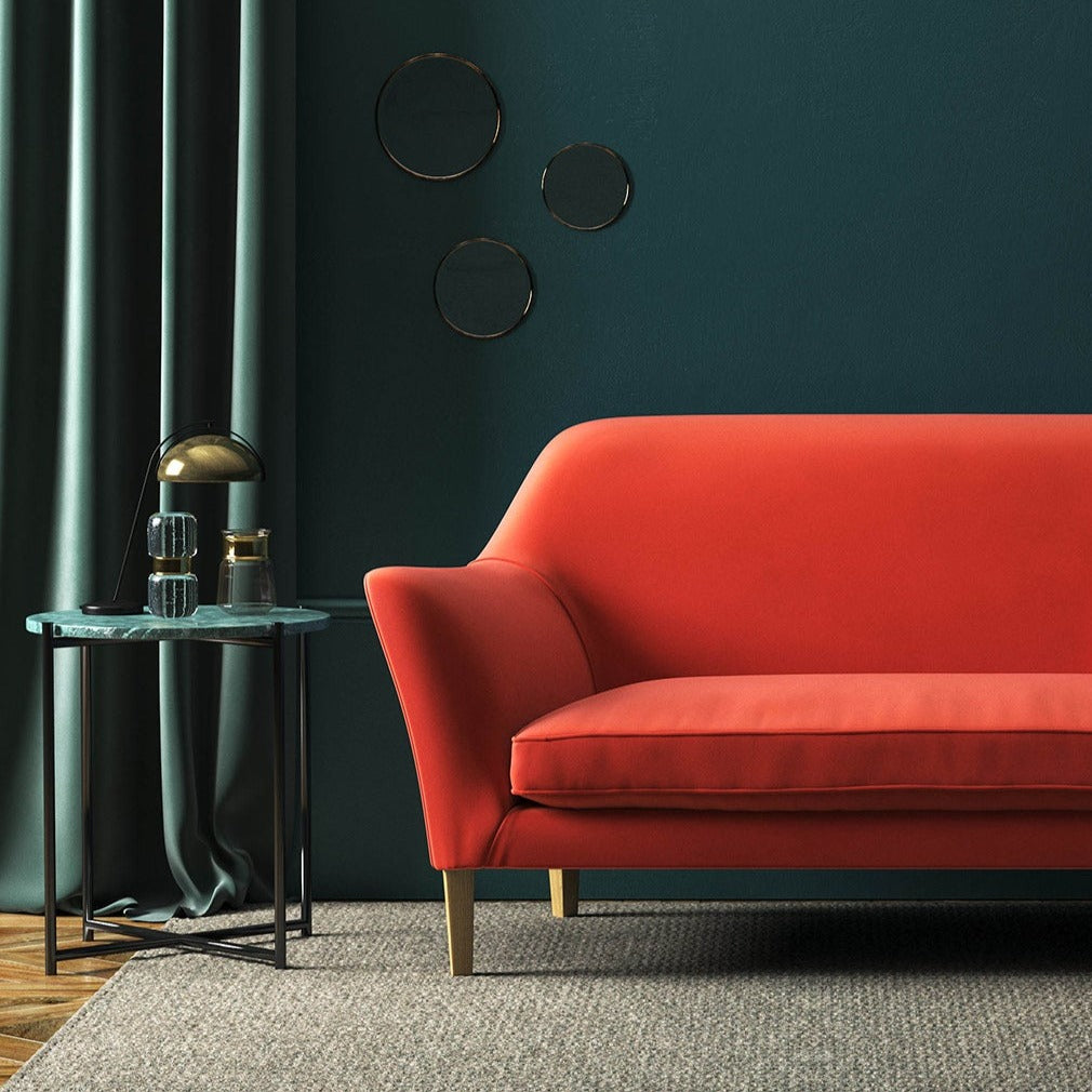 Sofa covered in a orange velvet upholstery fabric