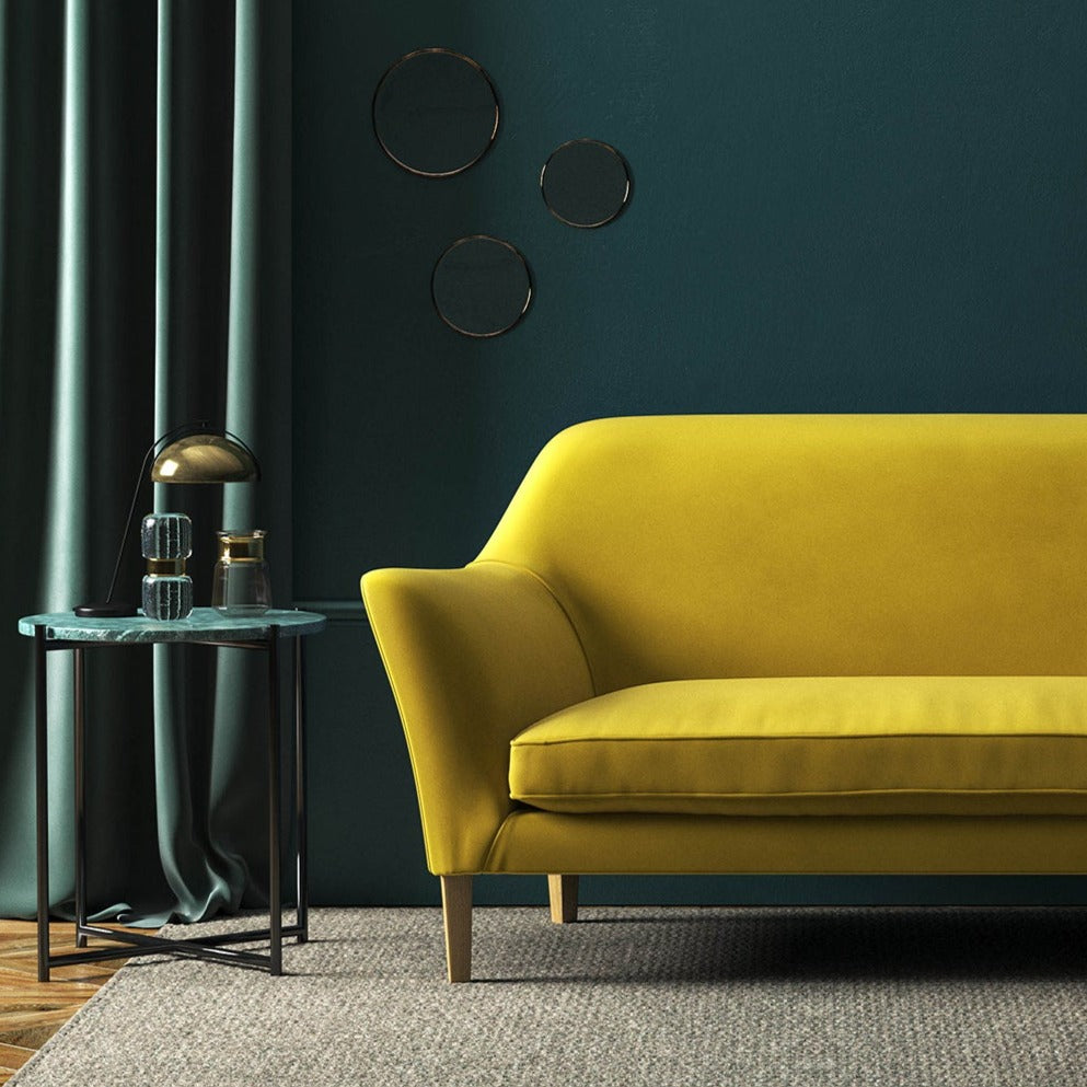 Sofa covered in a yellow velvet upholstery fabric