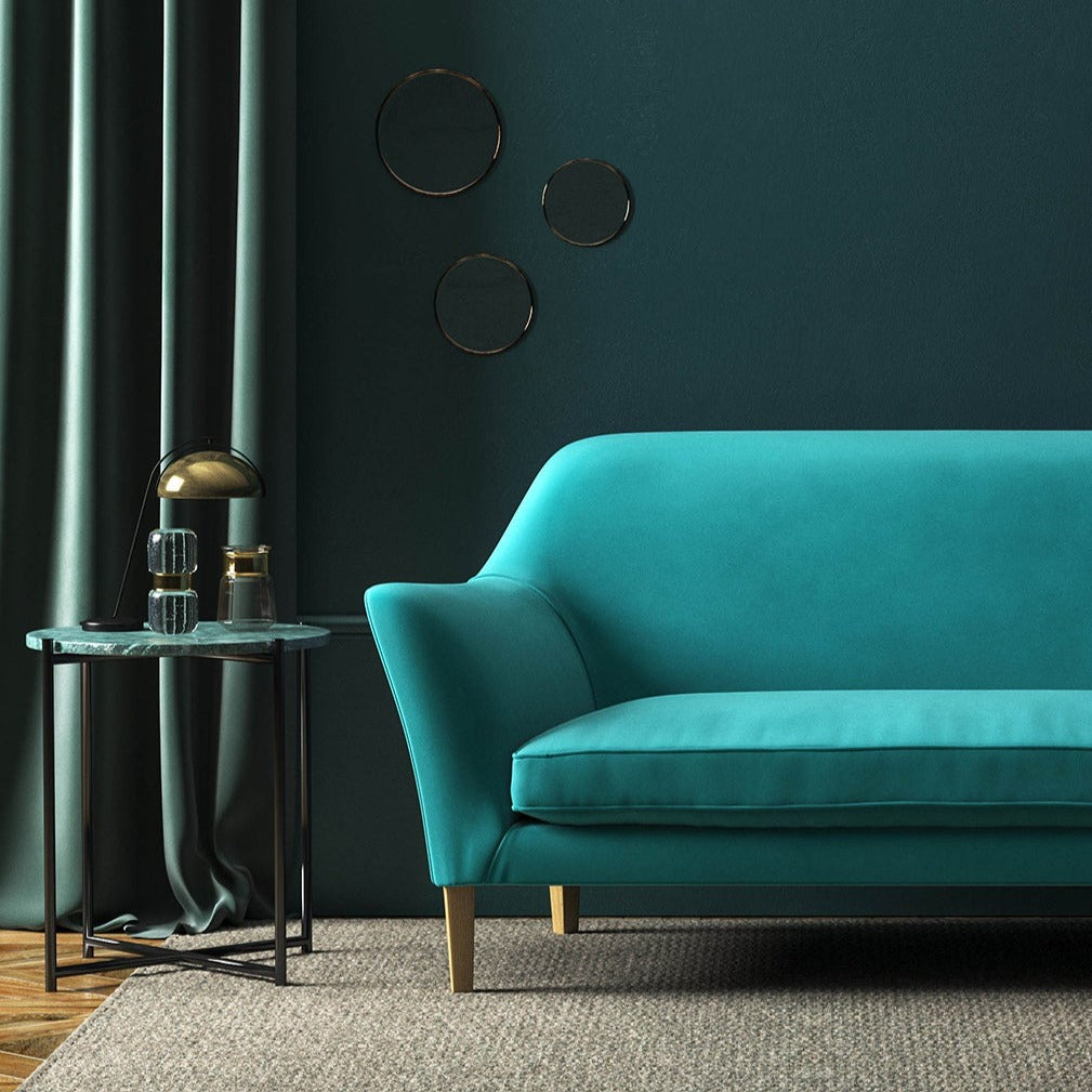 Sofa covered in a blue velvet upholstery fabric