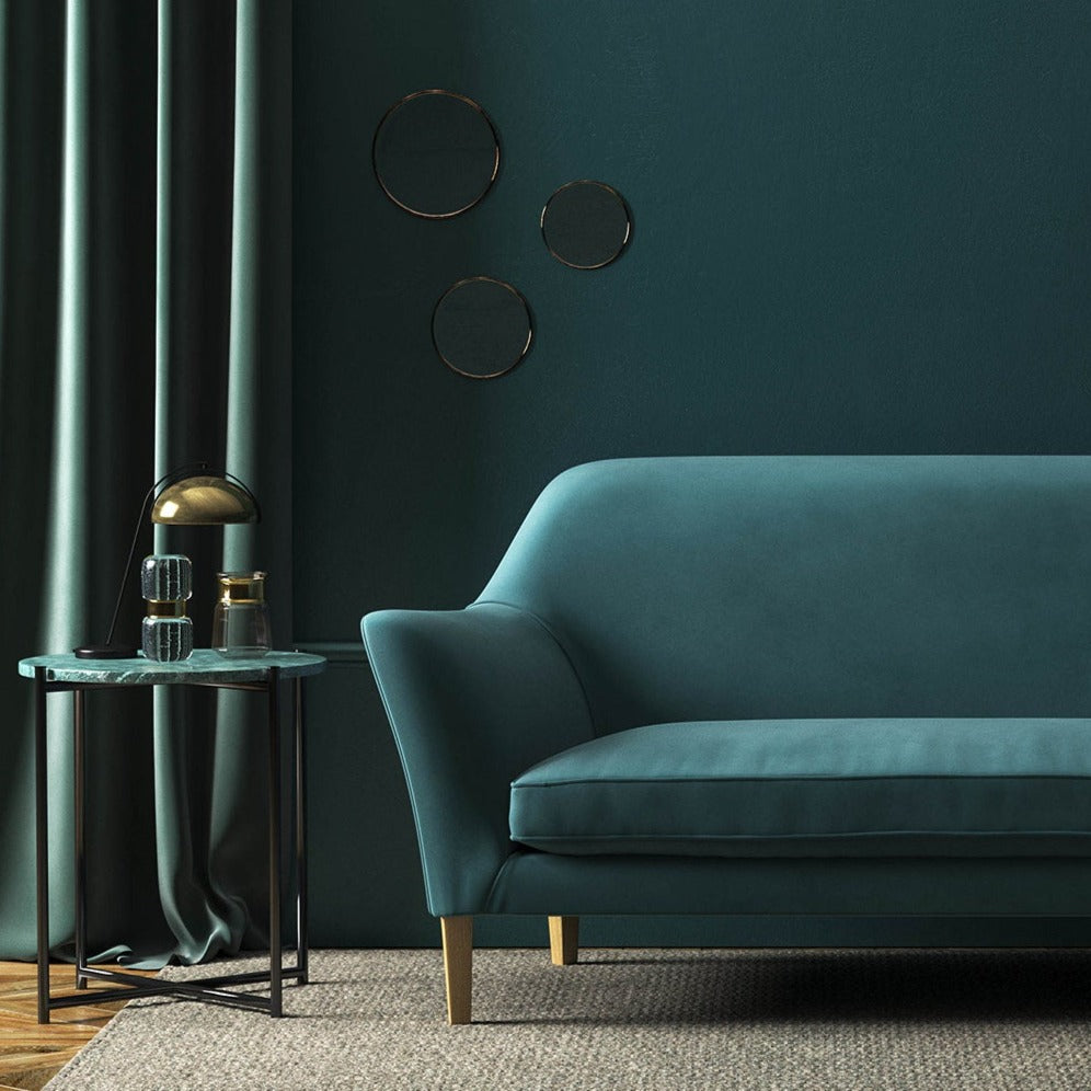 Sofa covered in a blue velvet upholstery fabric