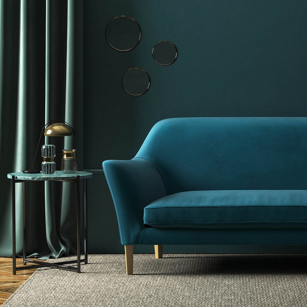 Sofa covered in a blue velvet upholstery fabric