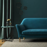 Sofa covered in a blue velvet upholstery fabric