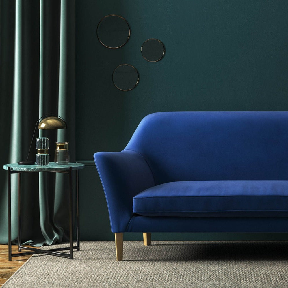 Sofa covered in a blue velvet upholstery fabric
