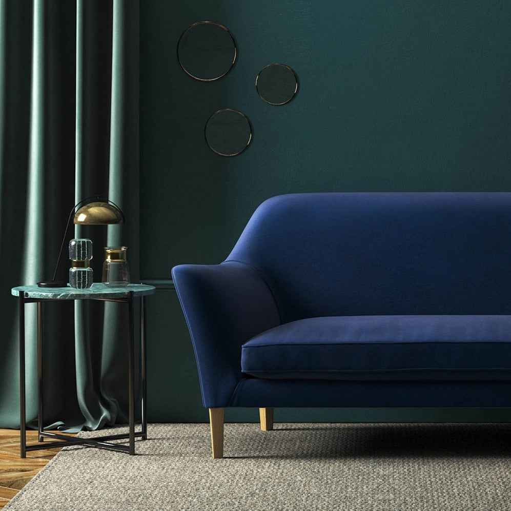 Sofa covered in a blue velvet upholstery fabric