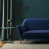 Sofa covered in a blue velvet upholstery fabric