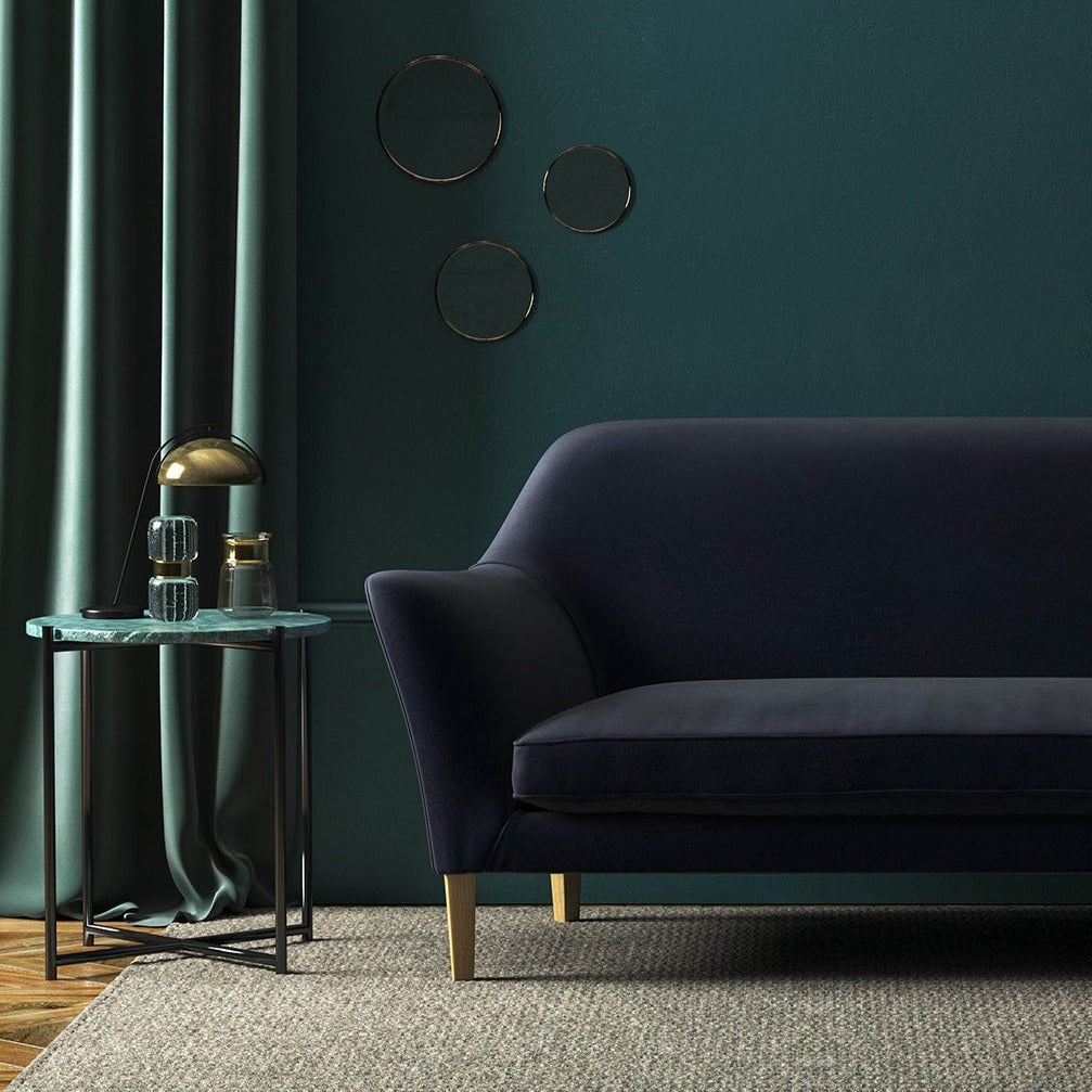 Sofa covered in a blue velvet upholstery fabric