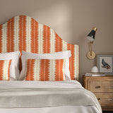 Headboard upholstered in a printed linen fabric in orange and off white, featuring a striped fern design.