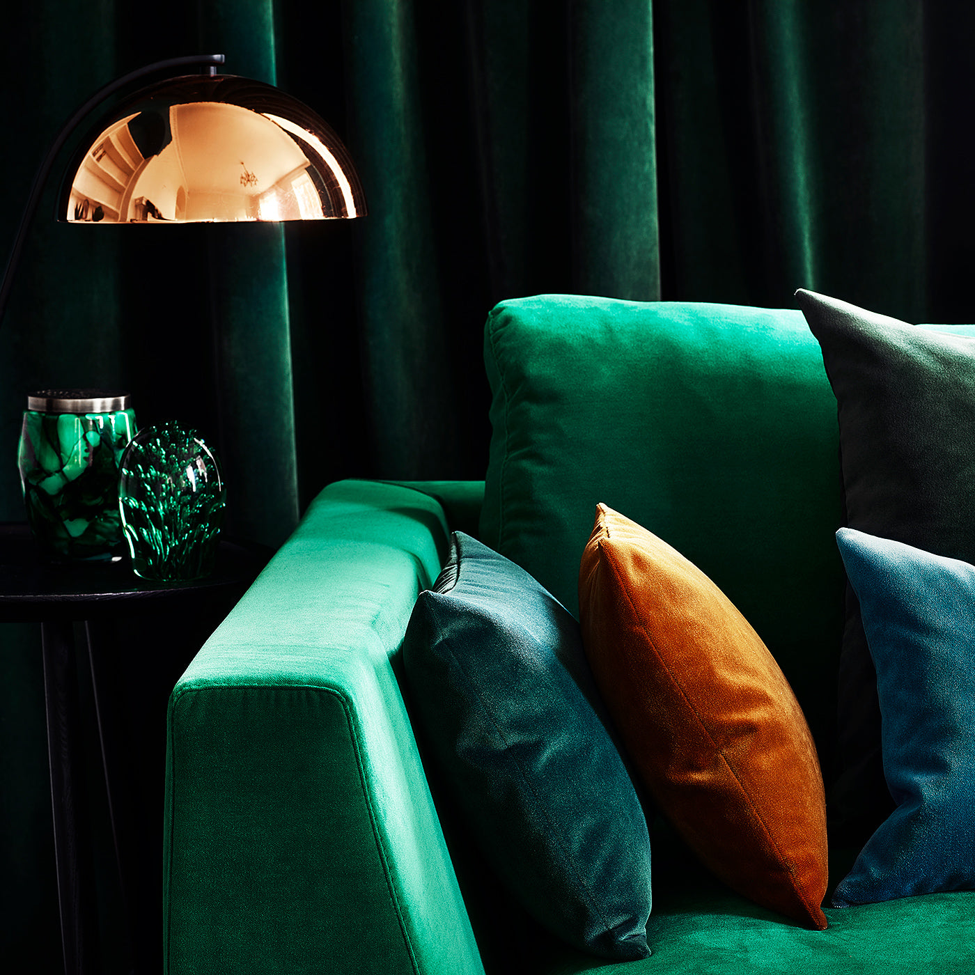 Sofa covered in a green velvet upholstery fabric