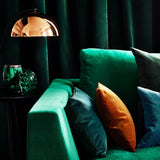 Sofa covered in a green velvet upholstery fabric 